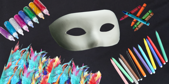 Art supplies surounding a blank Halloween mask, ready for decorating.