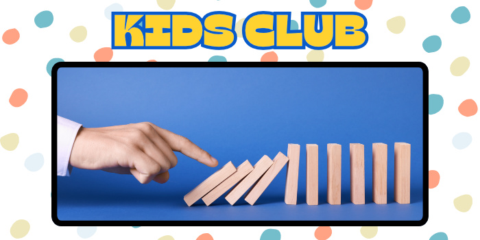 A finger poking a line up of dominos as they begin to fall in sequence.